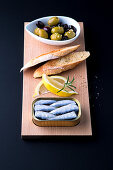 Oil sardines, lemons, toasted bread and pickled olives