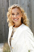 Young, blond woman in white coat outdoors