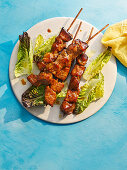 Sticky pork skewers with maple syrup and lettuce hearts