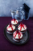 Chocolate cupcakes with vanilla topping and cherries