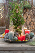 Weihnachtsdeko am Terrassentisch mit Kerzen, Christbaumkugeln, Zapfen, Zuckerhutfichte