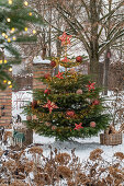 Geschmückter Christbaum im verschneiten Garten