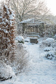 Verschneite Beete im winterlichen Garten