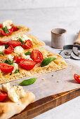 Pinsa with tomatoes, mozzarella and basil