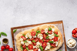 Pinsa with tomatoes, mozzarella and basil
