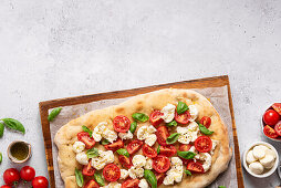 Pinsa mit Tomaten, Mozzarella und Basilikum