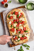 Pinsa with tomatoes, mozzarella, basil and olive oil