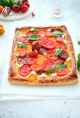 Puff pastry tart with cream cheese, tomatoes, garlic and basil