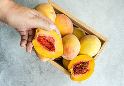 Wooden box with ripe organic peaches
