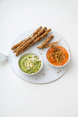Grissini with seeds, tomato dip, and guacamole