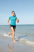 Young woman jogging by the sea