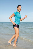 Young woman jogging by the sea