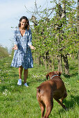 Brunette woman with dog in the garden