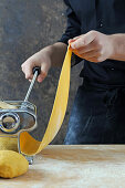 Rolling out pasta dough with a pasta machine