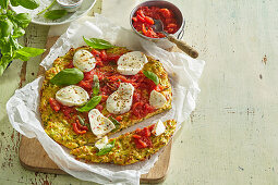 Zucchini pizza crust topped with tomatoes and mozzarella cheese