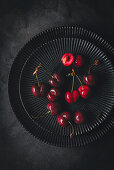 Fresh red cherries on black plates