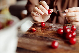 Pitting red cherries with a hairpin