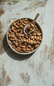 Organic pistachios in ceramic bowl on rustic wooden table