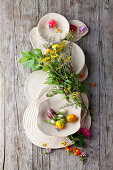 White ceramics with herbs, flowers and mini eggplants