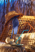 Kokoswasser auf Stuhl mit Tasche, Bikinioberteil und Sommerhut