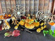 Gefüllte Mini-Kürbiskuchen, Salzstangen in Schlangenform, Schoko-Besen und Spinnennetze zu Halloween