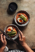 Cold Korean wheat noodles with soft-boiled egg in a spicy marinade made from gochujang paste