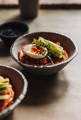 Cold Korean wheat noodles with soft-boiled egg in a spicy marinade made from gochujang paste