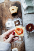 Linzer biscuits with red berry jam spread in a heart shape