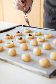 Preparing thumbprint cookies with jam filling
