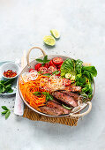 Rice noodle and vegetable bowl with grilled steak