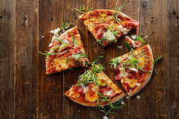 Wholemeal pizza with four types of cheese, sun-dried tomatoes, bresaola and rocket salad