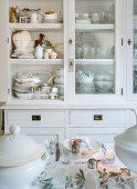 View over laid Christmas table to white sideboard with crockery