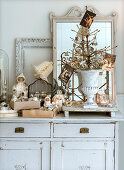 Bare Christmas tree with Christmas decorations and old cards in an urn, cotton dolls next to it