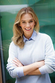 Young blonde woman wearing light-coloured shirt and jumper