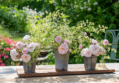 Weisse Rosen 'Stanwell Perpetual' (Rosa) als Strauß mit Wiesenlabkraut (Galium mollugo) in altem Zinkeimer auf der Terrasse