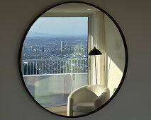 City view reflection in round wall mirror