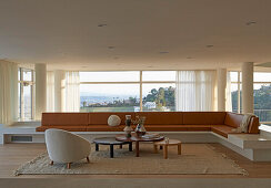 Seating area with cognac-colored leather upholstery and wall of windows