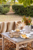 Gedeckter Kaffeetisch mit Orangen-Crostata im herbstlichen Garten