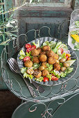 Fleischbällchen mit Olivenfüllung und Minze auf Salat