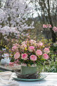 Bouquet of forsythia branches and roses, and birch branches as table decoration