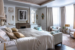 Cream-coloured bedroom with double bed, day bed and vintage armchairs from the 1940s