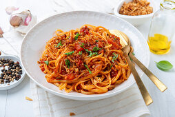 Vegan pasta with tomato and pepper sauce and fried onions