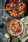 Potato gnocchi with herbs in tomato sauce and olives