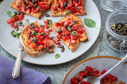 Geröstetes Brot mit Feta-Pesto-Aufstrich und Tomatensalat