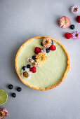 Vegan avocado and coconut tart with flower decoration and berries