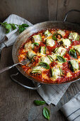 Gratinated courgette and soya mince rolls in tomato sauce