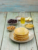 Banana pancakes stacked on a plate with topping ingredients