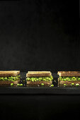 Sandwiches mit Erbsencreme vor schwarzem Hintergrund