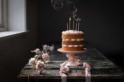 Vanille-Naked Cake mit rosa Zuckerguss und Kerzen