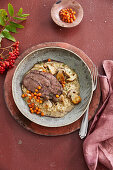 Roast wild boar on porcini mushroom risotto with pickled rowan berries